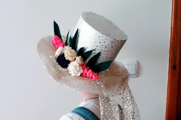 Biały kapelusz z dodatkiem kwiatowej kompozycji.