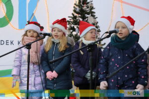 Czworo dzieci śpiewających na scenie.