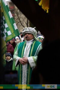 Mężczyzna ubrany w zielone ozdobne szaty.