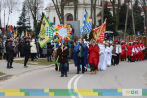 Liczna grupa ludzi idąca z gwiazdą i flagami.