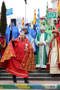 Mężczyzna przebrany w ozdobne szaty przemawia ze schodów.